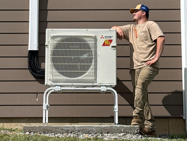 Installer leaning on Mini-Split Outside